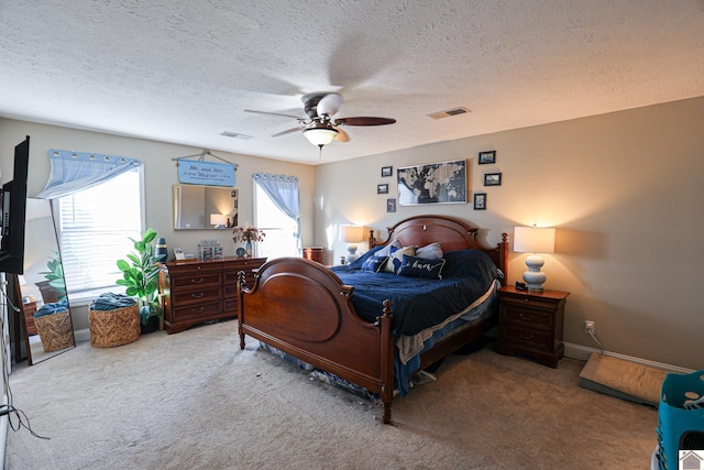 carpeted bedroom with a textured ceiling and ceiling fan