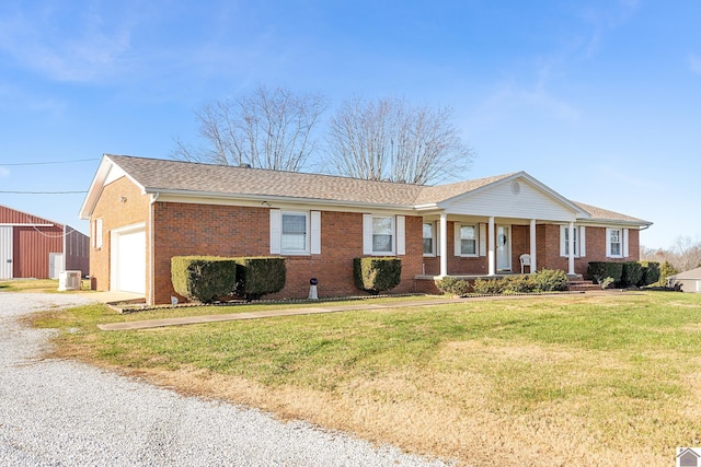 ranch-style home featuring a garage, cooling unit, a front lawn, and a porch