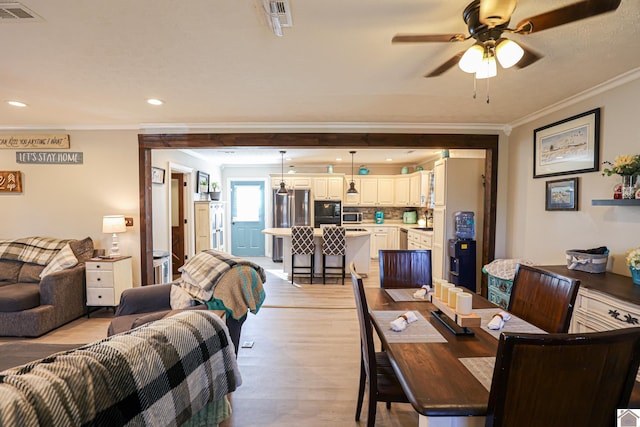 dining room with ceiling fan, light hardwood / wood-style flooring, and ornamental molding