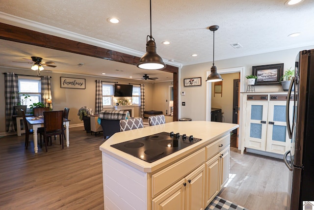 kitchen featuring black electric stovetop, stainless steel refrigerator, a textured ceiling, pendant lighting, and a center island