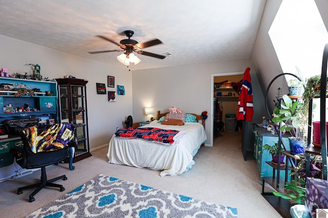 bedroom featuring ceiling fan, carpet flooring, a textured ceiling, a walk in closet, and a closet