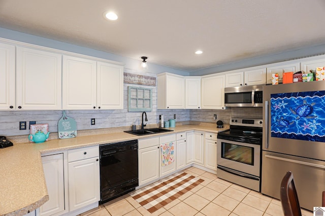 kitchen with light tile patterned floors, appliances with stainless steel finishes, white cabinetry, and sink