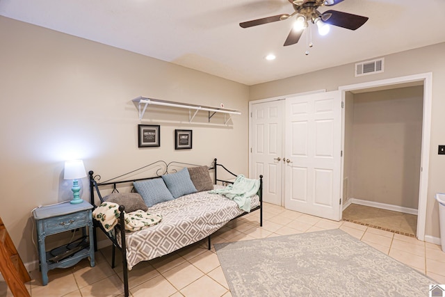 tiled bedroom with ceiling fan and a closet