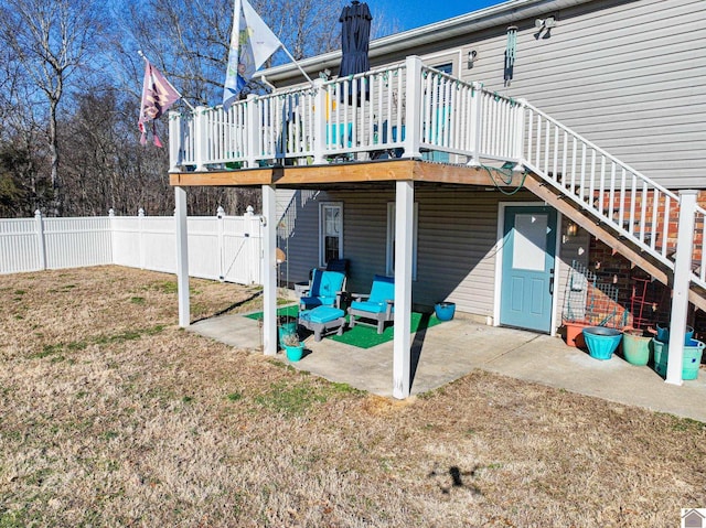 back of house featuring a deck, a yard, and a patio