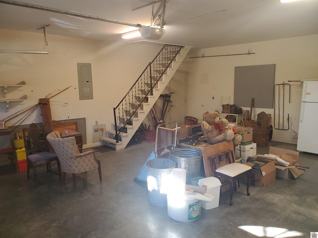 garage featuring a garage door opener, white fridge, and electric panel