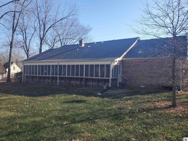 rear view of house with a sunroom and a lawn