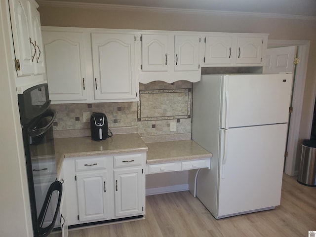 kitchen featuring white cabinets, backsplash, and white fridge