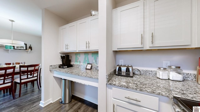 kitchen with decorative light fixtures, light stone counters, white cabinetry, and dark hardwood / wood-style floors