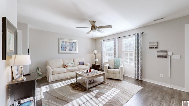 living room featuring ceiling fan and dark hardwood / wood-style floors