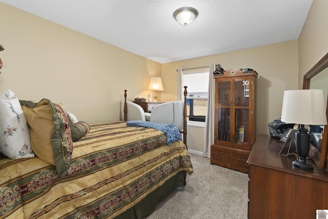 bedroom with a textured ceiling and light carpet