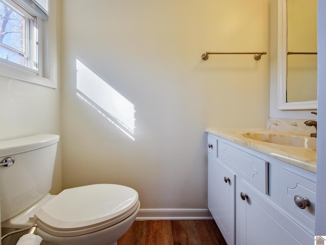 bathroom with hardwood / wood-style floors, toilet, and vanity