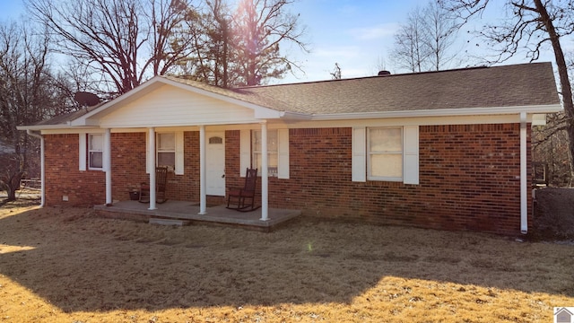 ranch-style home featuring a front lawn and covered porch