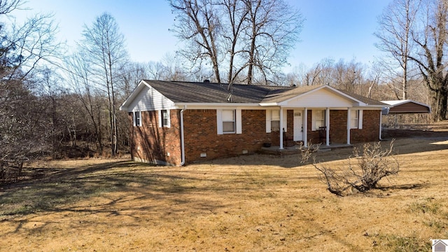 ranch-style house with a front yard, covered porch, and a carport