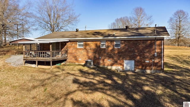 back of property with a lawn, central AC unit, and a deck