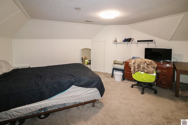 bedroom with light colored carpet, a textured ceiling, and vaulted ceiling