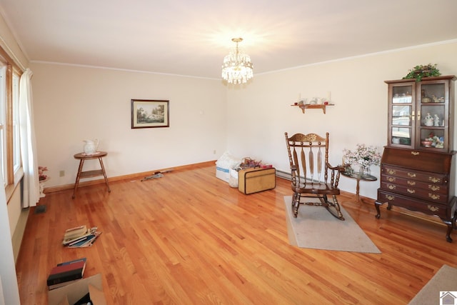 sitting room with ornamental molding, a chandelier, and wood-type flooring