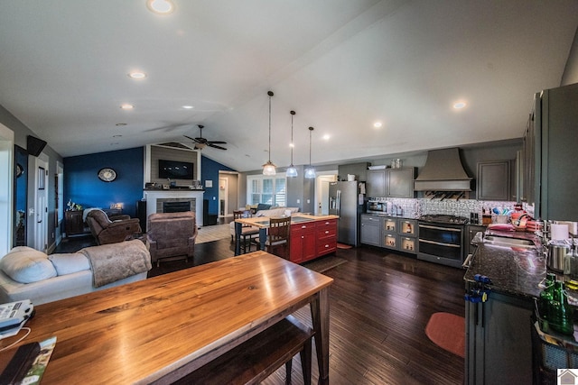 dining area featuring sink, vaulted ceiling, ceiling fan, and dark wood-type flooring