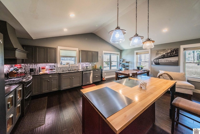 kitchen with dishwasher, decorative light fixtures, sink, backsplash, and vaulted ceiling