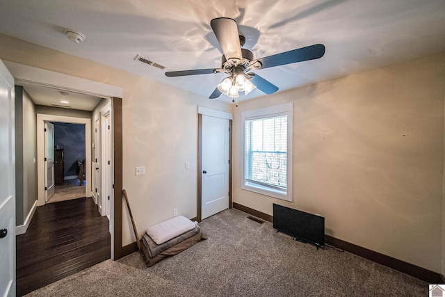 unfurnished bedroom featuring dark colored carpet and ceiling fan