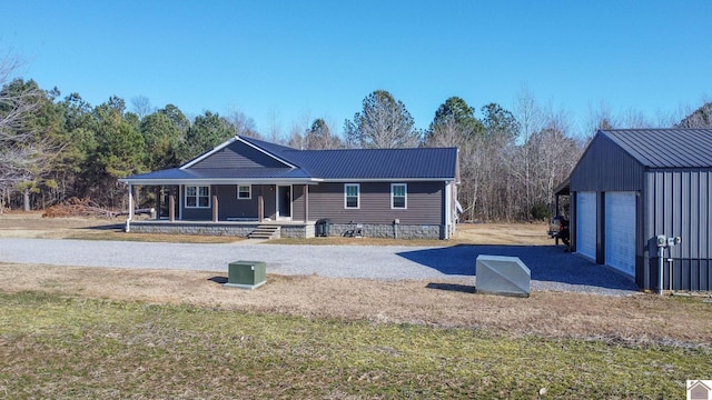 rear view of property with covered porch and a garage