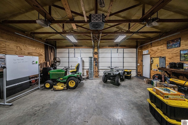 garage with wood walls, electric panel, and a garage door opener