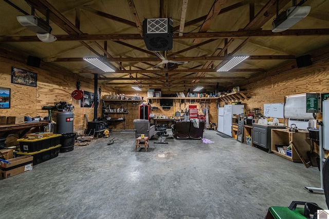 garage with a workshop area and wooden walls