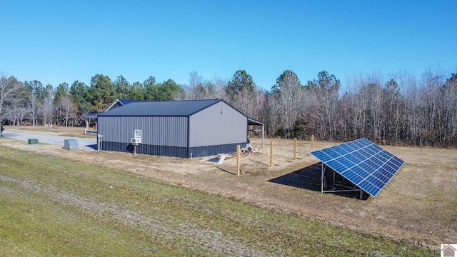 view of outbuilding featuring solar panels