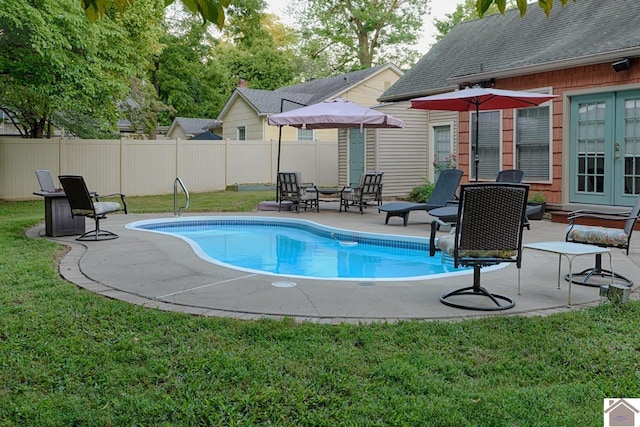 view of swimming pool featuring a patio area, a yard, and french doors