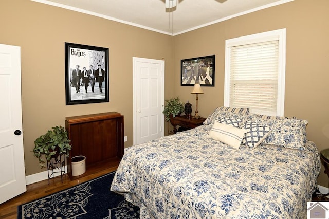 bedroom featuring crown molding, dark wood-type flooring, and ceiling fan