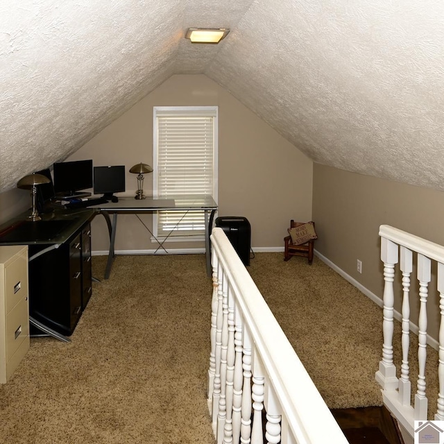 carpeted office with a textured ceiling and vaulted ceiling