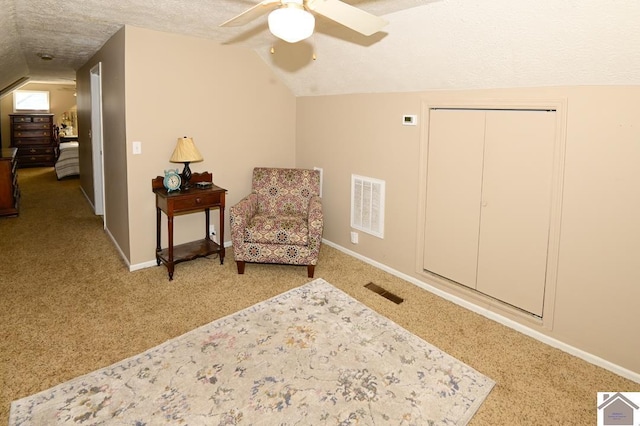 sitting room featuring ceiling fan, a textured ceiling, carpet flooring, and vaulted ceiling