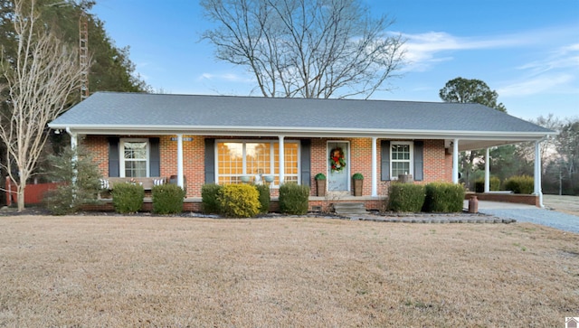 ranch-style home with a porch, a front lawn, and a carport