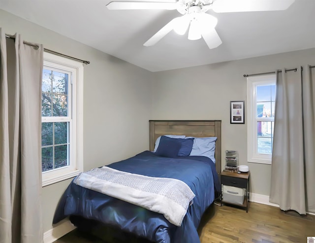 bedroom with wood-type flooring, multiple windows, and ceiling fan