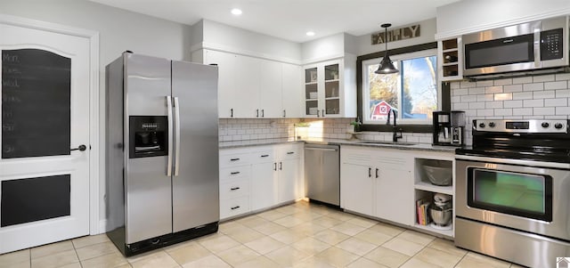 kitchen with white cabinets, appliances with stainless steel finishes, sink, hanging light fixtures, and light stone counters