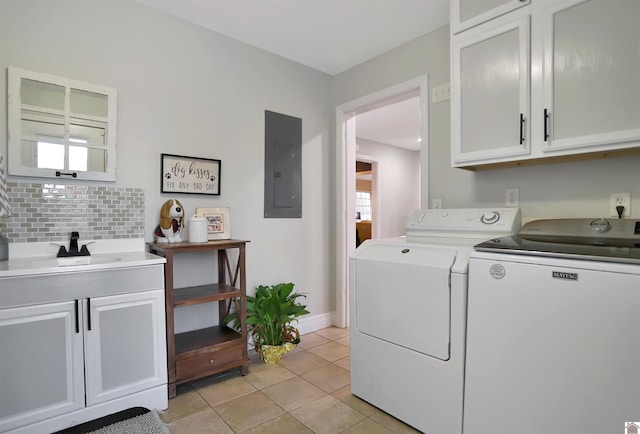 laundry room with sink, electric panel, washing machine and dryer, light tile patterned flooring, and cabinets