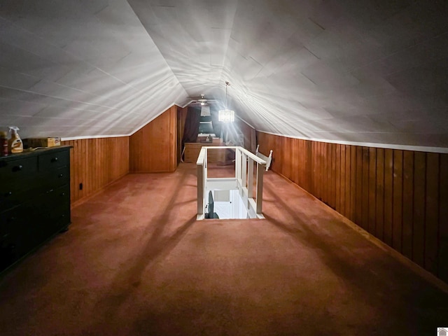 additional living space with wood walls, light carpet, and lofted ceiling