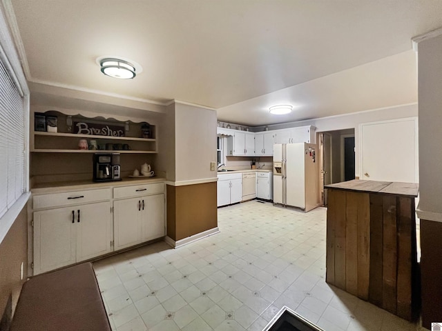 kitchen featuring sink, white appliances, and white cabinetry