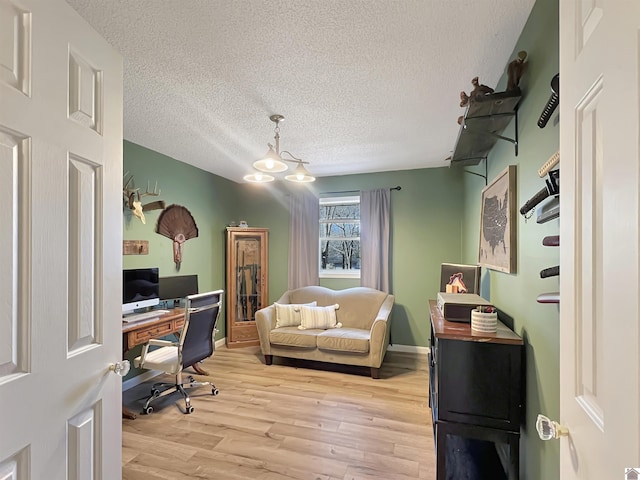 home office featuring a textured ceiling, a chandelier, and light hardwood / wood-style flooring