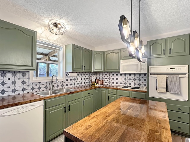 kitchen with white appliances, wooden counters, decorative backsplash, sink, and hanging light fixtures