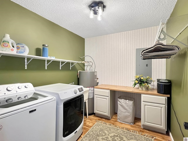 laundry area with water heater, cabinets, washing machine and dryer, and light wood-type flooring