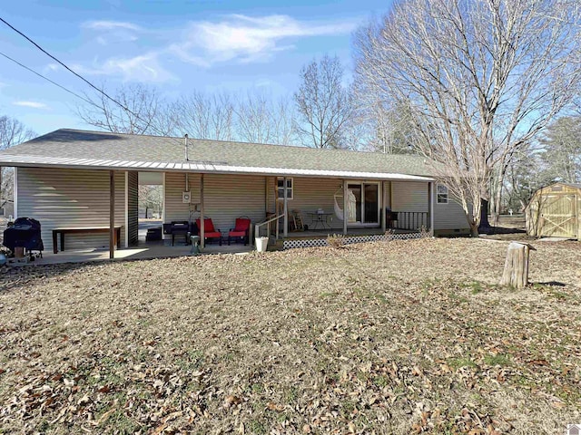 back of house with a storage unit, a patio, and a porch