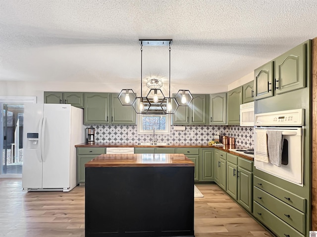 kitchen featuring white appliances, light hardwood / wood-style floors, wooden counters, decorative backsplash, and sink