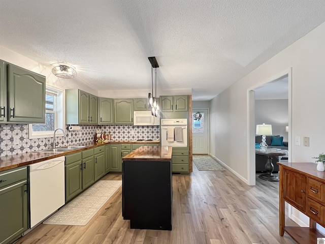 kitchen with sink, white appliances, green cabinetry, and wooden counters