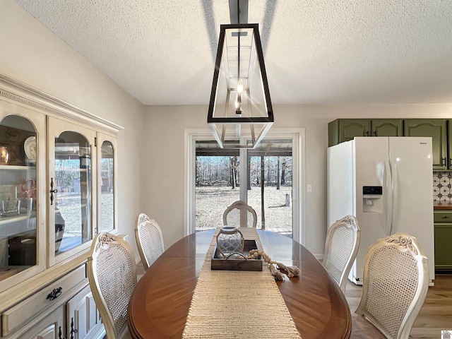 dining area with hardwood / wood-style flooring and a textured ceiling