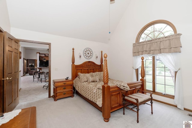 carpeted bedroom featuring high vaulted ceiling