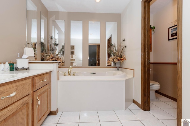 bathroom with a washtub, toilet, tile patterned floors, and vanity