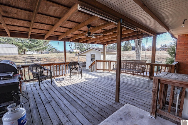 wooden terrace with ceiling fan and an outbuilding