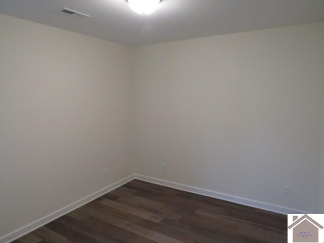 empty room with dark hardwood / wood-style flooring