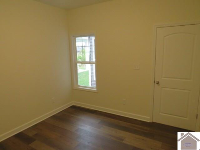 spare room featuring dark wood-type flooring