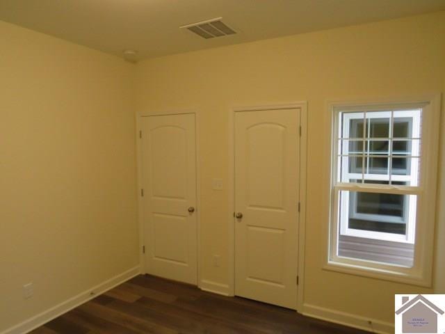 unfurnished bedroom featuring dark hardwood / wood-style flooring